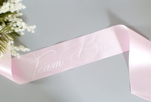 Load image into Gallery viewer, Pink satin sash with Team Bride in white cursive text.