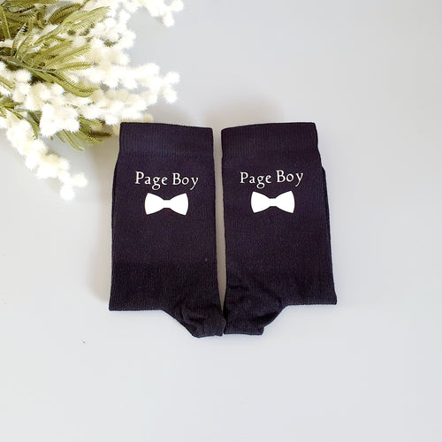 Children's black socks with a white bow tie and page boy written on the side. 