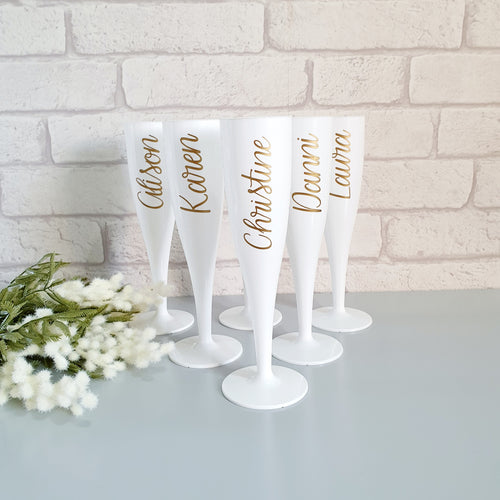 White, biodegradable plastic prosecco flutes personalised with the name or wedding role of your choice. 
