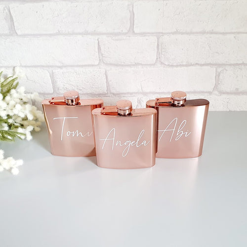 high shine rose gold hip flask with white cursive text