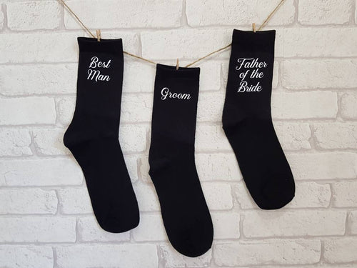 black cotton men's socks with wedding roles in white text. 