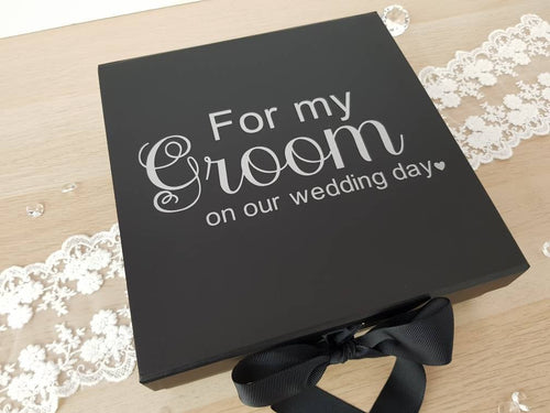 square black card gift box with silver text on the front. 