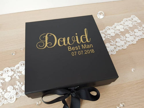 square black gift box with name, role and wedding date on the front in gold text. 
