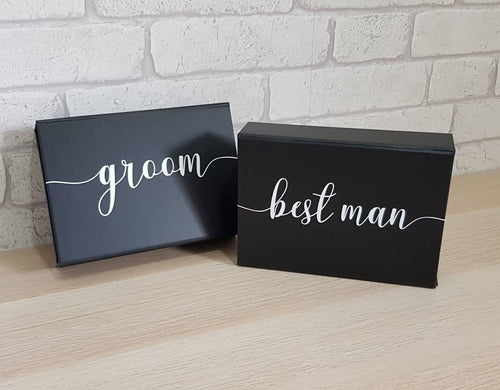 small black rectangular gift box with white text. 