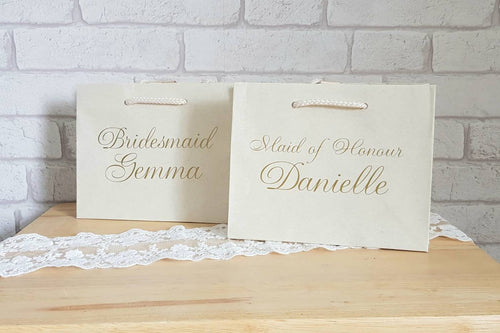 small cream gift bag with name and role in gold italic text on the front. 