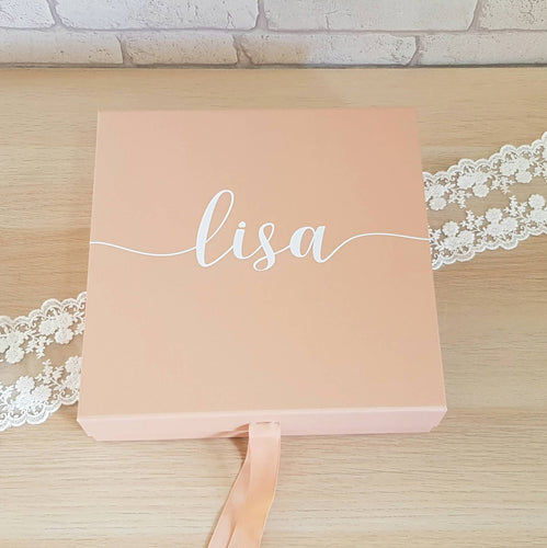 rose gold card gift box with ribbon tie and white text across the front. 