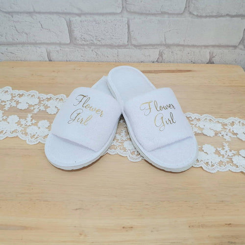 white cotton/polyester open toe slippers with rubber sole. Flower Girl written across the front. 