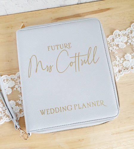 Saffiano leather look fabric with high shine gold zip. Inside has lots of compartments for all your wedding planning bits and bobs.